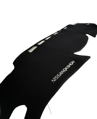 Black car mat with 'Nissan Qashqai' branding on a vehicle interior.
