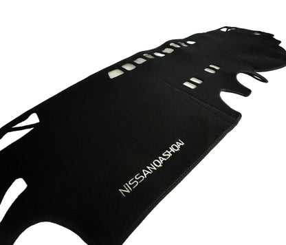 Black car mat with 'Nissan Qashqai' branding on a white surface.