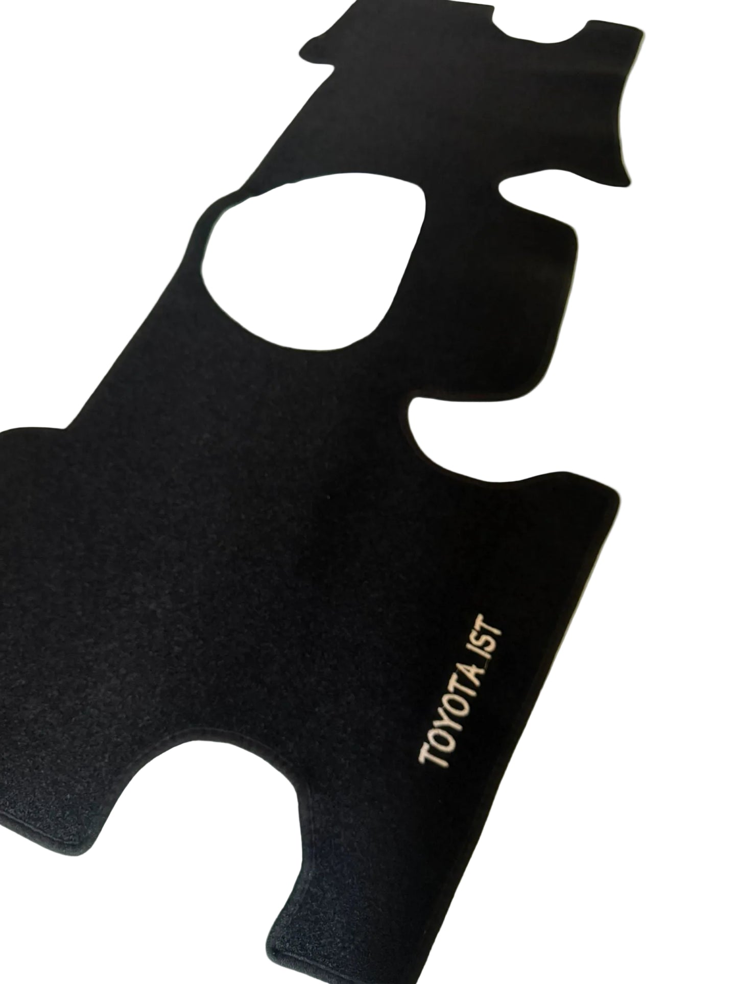 Black car mat with 'TOYOTA IST' branding on a light-colored floor.