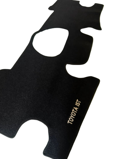 Black car mat with 'TOYOTA IST' branding on a light-colored floor.