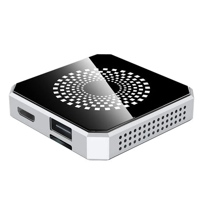 A compact square mini PC or desktop computer with a glossy black top panel featuring a white geometric circular pattern, and a silver metallic side frame with visible ports and ventilation holes.
