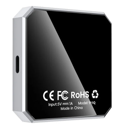 A square electronic device with a glossy black faceplate and a silver metallic frame, featuring white text with CE, FC, RoHS, and other specifications on the front.