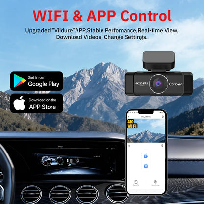Car dashboard with a camera and smartphone displaying app interface, mountainous landscape in the background.